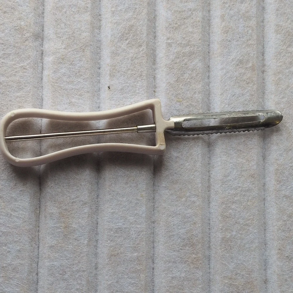 Manual Serrated Vegetable Peeler with‎ White Plastic Handle and Metal Blade